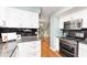 Well-lit kitchen featuring white cabinets, stainless steel appliances, granite countertops, and black tiled backsplash at 8061 Lower Bay Ln # 1, Indianapolis, IN 46236
