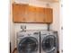 Laundry room includes a modern washer and dryer, as well as overhead cabinets at 8061 Lower Bay Ln # 1, Indianapolis, IN 46236