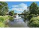 Scenic waterfront view featuring a fountain, lush greenery, and nearby residences at 8061 Lower Bay Ln # 1, Indianapolis, IN 46236