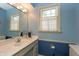 Bathroom with blue walls, marble vanity, and large mirror and window at 9080 Dewberry Ct, Indianapolis, IN 46260