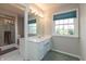 Bright bathroom features a large window, updated vanity with white countertops, and a glass-enclosed shower at 9080 Dewberry Ct, Indianapolis, IN 46260