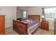 Cozy bedroom with hardwood furniture, two bright windows, and neutral walls at 9080 Dewberry Ct, Indianapolis, IN 46260