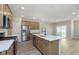 A kitchen featuring stainless steel appliances, a center island with sink, and views into the living area at 9742 Behner Dr, Fishers, IN 46250