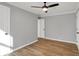 This is a bedroom with a view of the hallway, wood floor, ceiling fan, and fresh light-grey paint at 1195 W Edgewood Ave, Indianapolis, IN 46217