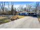 Ranch-style home featuring blue siding, a long driveway, and mature trees at 1195 W Edgewood Ave, Indianapolis, IN 46217