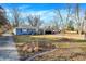 Landscaped front yard with a blue house, driveway, and mature trees at 1195 W Edgewood Ave, Indianapolis, IN 46217