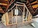 Unfinished attic with visible framework, exposed rafters, and natural light from window at 120 Wisconsin St, Indianapolis, IN 46225