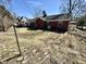 View of the backyard with brick home and sunroom, presenting a serene outdoor space at 1410 E 8Th St, Anderson, IN 46012