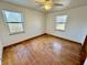 Hardwood floors with inlay design, fan, and two windows add charm to this bedroom at 1410 E 8Th St, Anderson, IN 46012