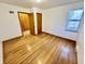 Bedroom features hardwood floors, a large window with blinds, and access to the hallway at 1410 E 8Th St, Anderson, IN 46012