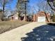 Charming single-story home with brick facade, attached garage and long concrete driveway at 1410 E 8Th St, Anderson, IN 46012