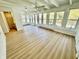 Bright sunroom with wood floors, many windows, a ceiling fan, and door to the outside at 1410 E 8Th St, Anderson, IN 46012