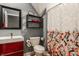 Cozy bathroom with a modern sink, mirror, toilet, and a shower with a unique patterned curtain at 1424 S New Jersey St, Indianapolis, IN 46225