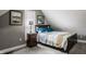 Bedroom featuring a bed with patterned bedding, a nightstand with a lamp, and natural light from a window at 1424 S New Jersey St, Indianapolis, IN 46225