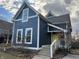 Charming two-story home with blue siding, white trim, a bright yellow door, and manicured landscaping at 1424 S New Jersey St, Indianapolis, IN 46225