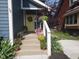 Inviting front entrance featuring concrete steps, white railings, a vibrant yellow door, and lush plants at 1424 S New Jersey St, Indianapolis, IN 46225