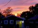 Detached garage with a yellow door and a beautiful sunset backdrop, creating a serene atmosphere at 1424 S New Jersey St, Indianapolis, IN 46225