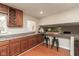 Kitchen with wood cabinets, granite countertops, wood floors, bar-stool seating, and open access to the living area at 1431 W Edgewood Ave, Indianapolis, IN 46217