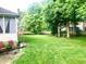 Well-maintained backyard with lush green lawn, mature trees, and outdoor seating area at 1470 Northern Valley Trl, Avon, IN 46123