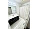 Bathroom featuring a single sink vanity, tiled flooring and a shower/tub with a white curtain at 1470 Northern Valley Trl, Avon, IN 46123