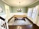 Dining room features green accent wall, wainscoting, hardwood floor, and chandelier at 1470 Northern Valley Trl, Avon, IN 46123