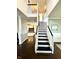 Bright foyer features staircase with dark steps, fireplace, and hardwood floors at 1470 Northern Valley Trl, Avon, IN 46123