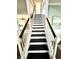 Carpeted staircase with a two-tone design and wooden banister at 1470 Northern Valley Trl, Avon, IN 46123