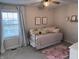 Neutral bedroom with patterned daybed, pink rug, ceiling fan, and bright natural light from the window at 15050 Bainbridge Ct, Westfield, IN 46074