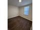This bedroom features hardwood-style floors and a window for natural light at 1509 S Hawthorne Ln, Indianapolis, IN 46203