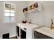 Well-lit laundry room featuring modern washer and dryer, sink, and storage shelves for convenience at 15297 Fairlands Dr, Westfield, IN 46074
