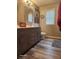 Well-lit bathroom features wood-look floors, a vanity, and framed mirror at 16 Torrey Pine Dr, Brownsburg, IN 46112