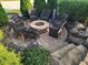 Outdoor fire pit surrounded by stone pavers, landscaping, and comfortable wicker seating for guests at 16 Torrey Pine Dr, Brownsburg, IN 46112