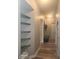 Hallway featuring floating shelves and a mudroom with a wooden bench and shelf in the background at 16 Torrey Pine Dr, Brownsburg, IN 46112