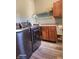 Laundry room with modern washer and dryer, wooden cabinets, and ample countertop space at 16 Torrey Pine Dr, Brownsburg, IN 46112