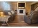 Cozy living room showcasing a fireplace with a mantel, hardwood floors, and comfortable recliners at 16 Torrey Pine Dr, Brownsburg, IN 46112