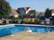 Community pool surrounded by lounge chairs and black metal fencing, with mature trees in the background at 16 Torrey Pine Dr, Brownsburg, IN 46112