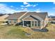 Aerial view of a brick home with a covered patio and spacious lawn at 1684 Hedley W Way, Avon, IN 46123