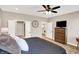 Bedroom view showcasing wood flooring, doors to the bathroom and laundry, and a ceiling fan at 1684 Hedley W Way, Avon, IN 46123