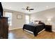 Comfortable bedroom with wood floors, ceiling fan, and natural light from large windows at 1684 Hedley W Way, Avon, IN 46123