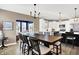 Open-concept dining area with a chandelier, hardwood floors, and an adjacent modern kitchen and living area at 1684 Hedley W Way, Avon, IN 46123