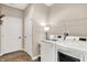 Bright laundry room with white washer and dryer, featuring a white door and shelving at 1684 Hedley W Way, Avon, IN 46123
