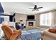 Comfortable living room featuring a stone fireplace, ceiling fan, and views into the entry and second living area at 1684 Hedley W Way, Avon, IN 46123