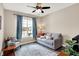 Bright living room with a gray sofa, accent chair, rug, and a window with blue curtains at 1684 Hedley W Way, Avon, IN 46123