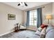 Comfortable living room featuring a gray sofa, accent chair, rug, and a window with curtains at 1684 Hedley W Way, Avon, IN 46123