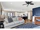 Open-concept living room featuring hardwood floors, large couch, open to the kitchen and dining area at 1684 Hedley W Way, Avon, IN 46123