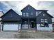 Two-story home showcasing a modern farmhouse design with black vertical siding and a white garage door at 19854 Chatham Shore Ln, Westfield, IN 46074