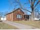 Side view of brick home featuring a detached garage and a paved driveway at 2022 Newton St, Columbus, IN 47201
