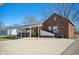 Rear exterior showcasing covered carport, brickwork, and well-maintained grounds at 2022 Newton St, Columbus, IN 47201