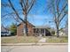 Charming brick home with a covered front porch, mature trees, and a well-maintained lawn at 2022 Newton St, Columbus, IN 47201