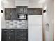 Kitchen featuring dark gray cabinets, granite countertops, white appliances, and a tile backsplash at 2022 Newton St, Columbus, IN 47201